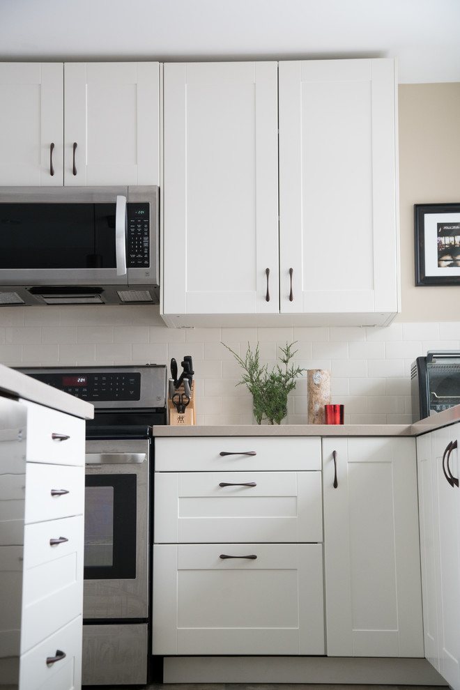 Inspiration for a transitional kitchen remodel in Toronto with white cabinets and white backsplash