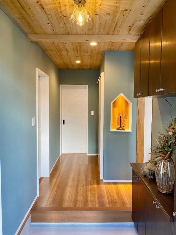 Nordische Haustür mit weißer Wandfarbe, Sperrholzboden, Einzeltür, brauner Haustür, braunem Boden, Tapetendecke und Tapetenwänden in Sonstige