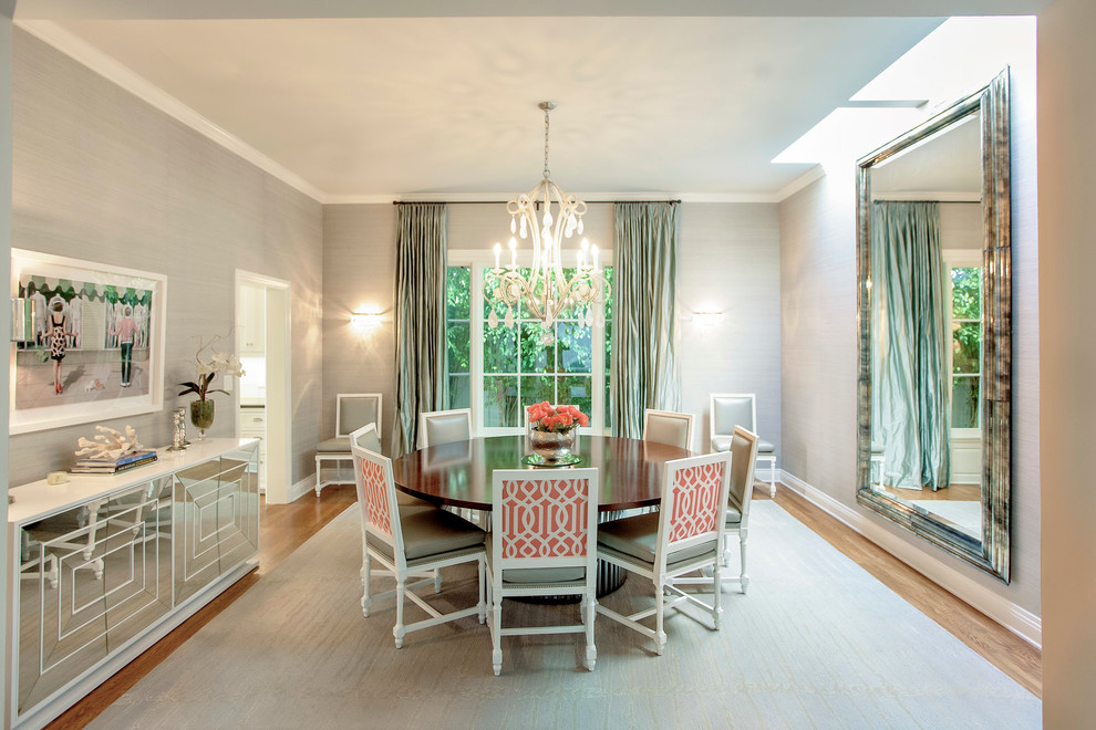 Example of a transitional medium tone wood floor enclosed dining room design in Los Angeles with gray walls