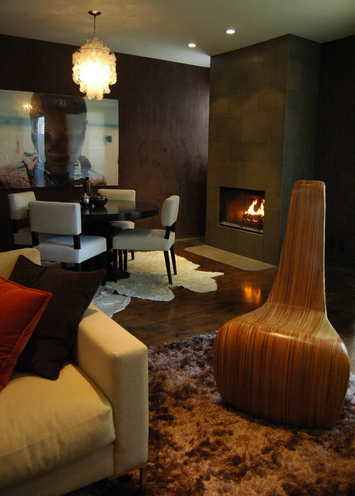 Design ideas for a modern family room in Los Angeles with brown walls, dark hardwood floors and a standard fireplace.