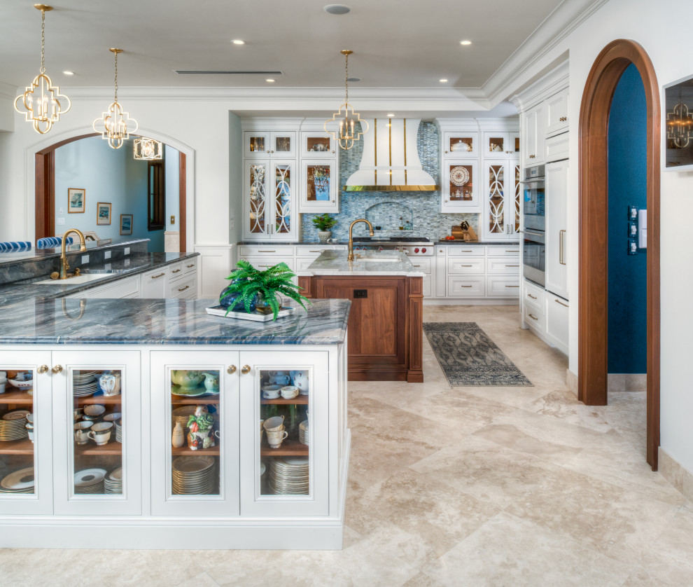 Inspiration for an expansive transitional l-shaped eat-in kitchen in Other with an undermount sink, raised-panel cabinets, white cabinets, quartzite benchtops, blue splashback, glass tile splashback, stainless steel appliances, terrazzo floors, with island and multi-coloured benchtop.