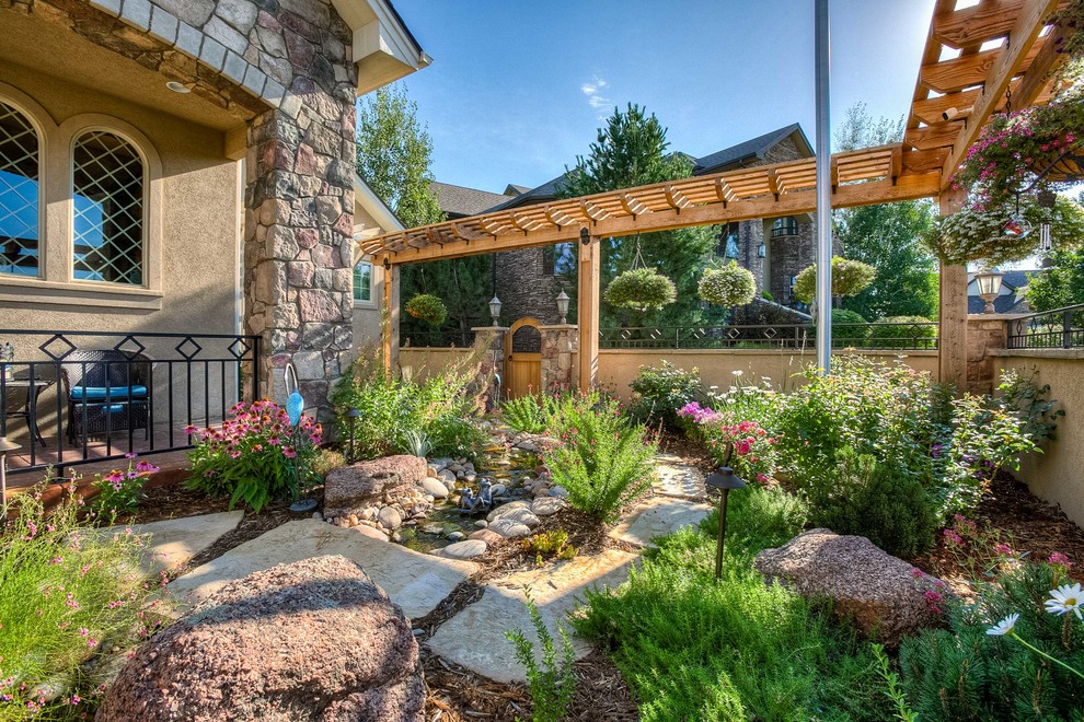 Inspiration for a mid-sized transitional partial sun front yard stone walkway in Denver.