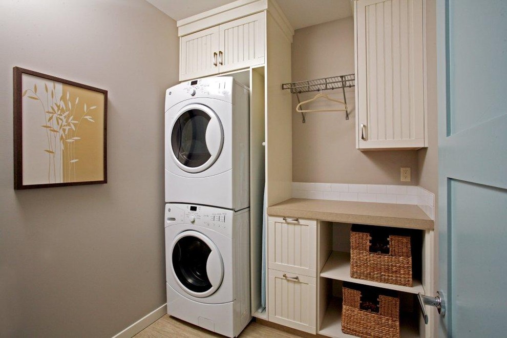 Inspiration for a traditional laundry room in Calgary with a stacked washer and dryer.