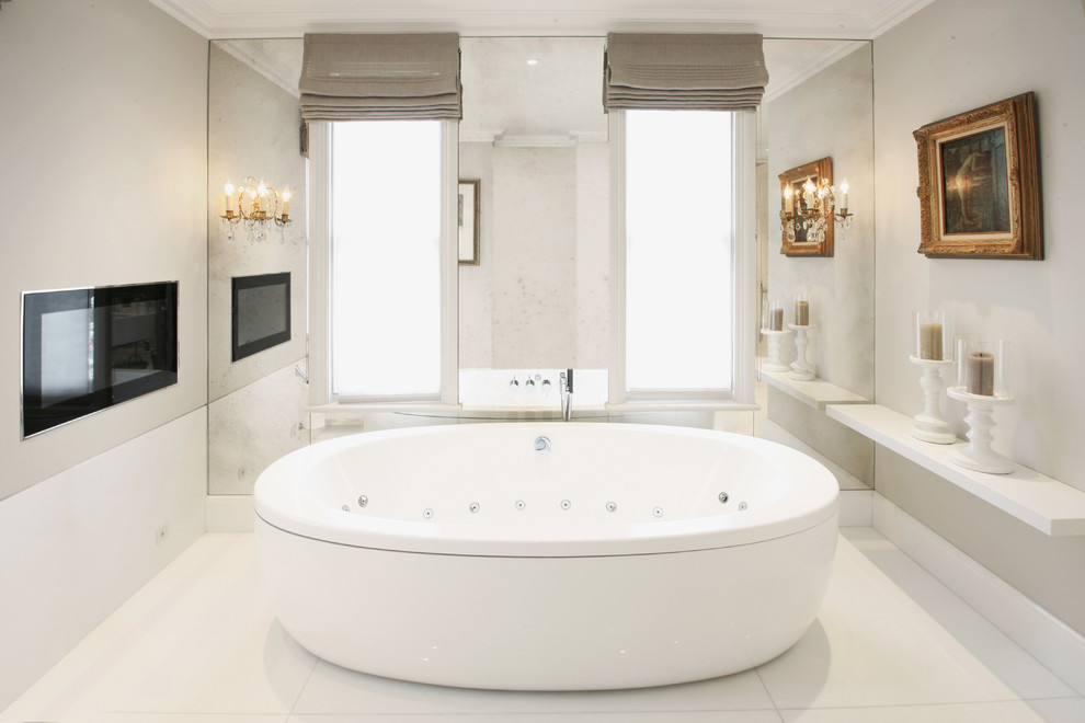 Photo of a contemporary master bathroom in London with a hot tub and beige walls.