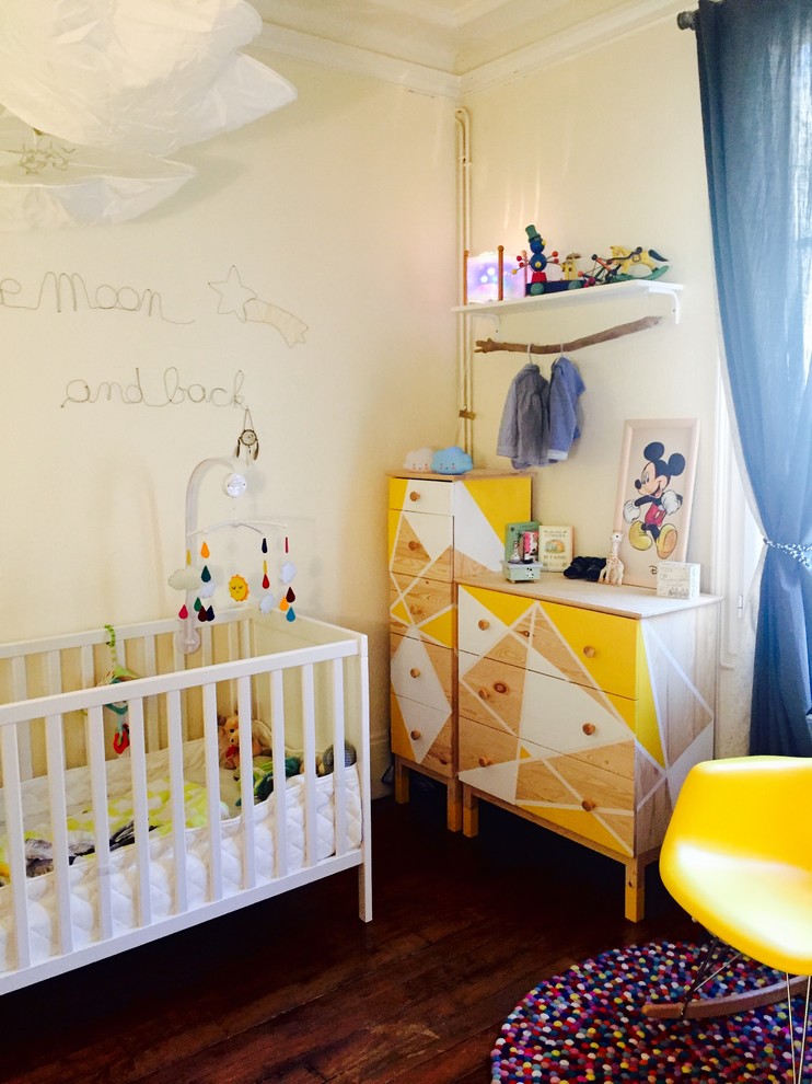 Mid-sized modern nursery in Paris with white walls and dark hardwood floors for boys.