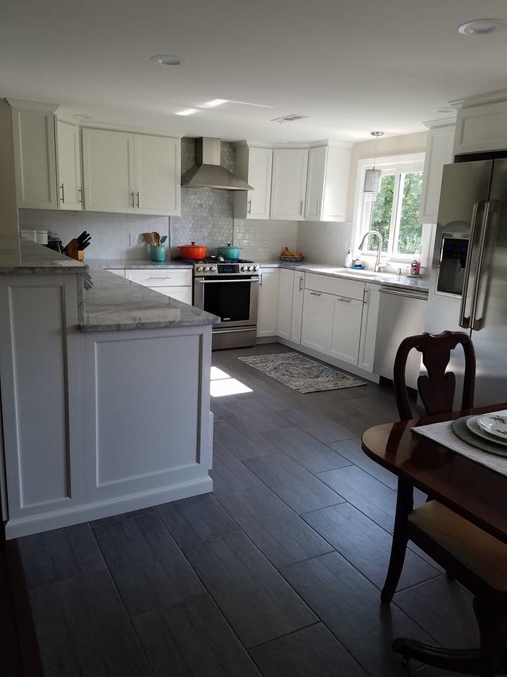 Mid-sized transitional u-shaped dark wood floor and brown floor eat-in kitchen photo in Providence with an undermount sink, recessed-panel cabinets, white cabinets, granite countertops, white backsplash, subway tile backsplash, stainless steel appliances, a peninsula and gray countertops