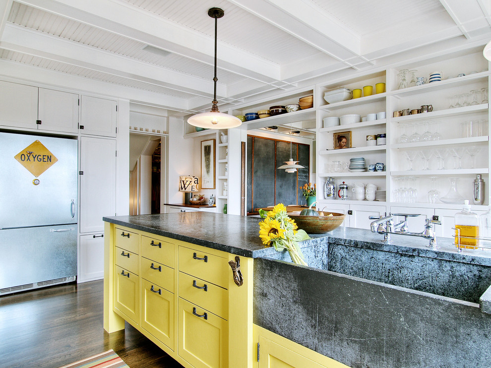 This is an example of an eclectic kitchen in Seattle with stainless steel appliances, an integrated sink, open cabinets, yellow cabinets and soapstone benchtops.