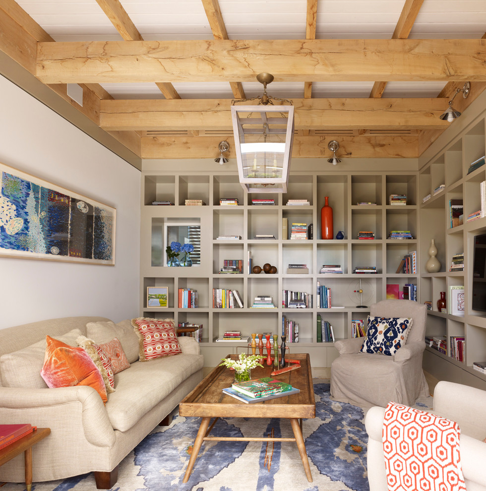 Family room library - contemporary family room library idea in New York with beige walls and a media wall