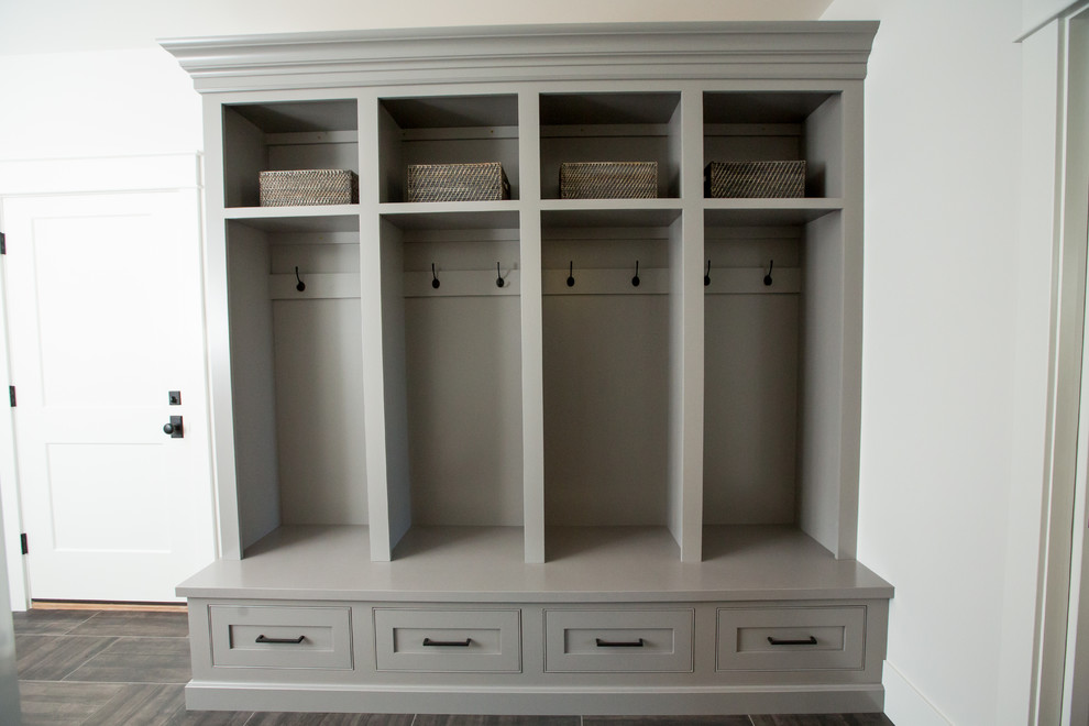 This is an example of a large transitional mudroom in Other with white walls, porcelain floors and grey floor.