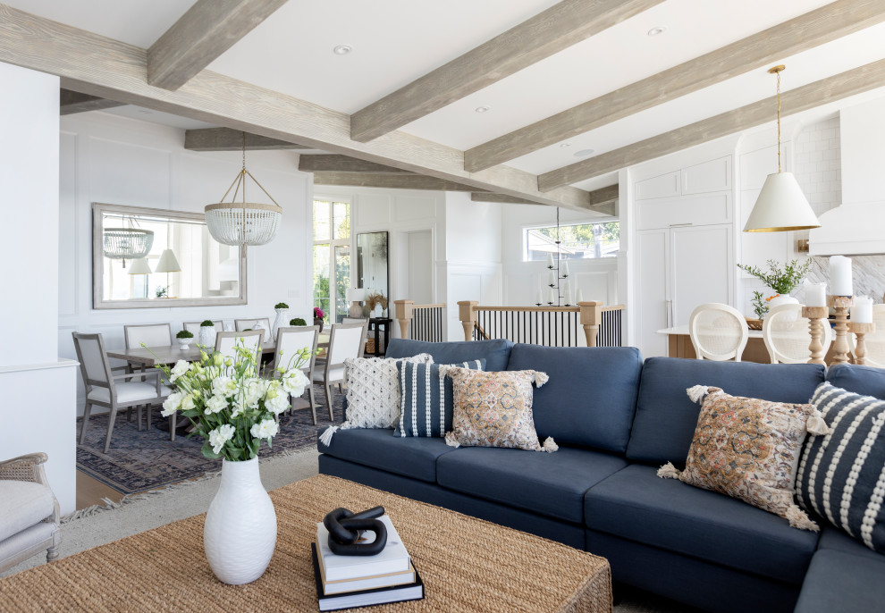 Photo of a coastal open plan living room in Vancouver with light hardwood flooring, beige floors, exposed beams and wainscoting.
