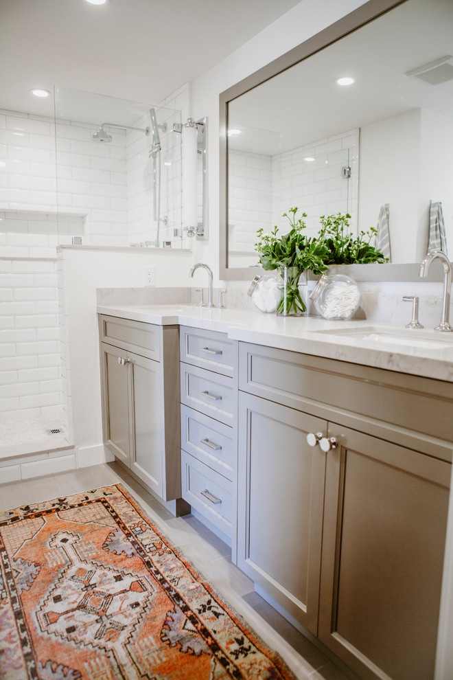Design ideas for a mid-sized beach style master bathroom in San Diego with shaker cabinets, grey cabinets, an alcove shower, a one-piece toilet, white tile, ceramic tile, white walls, ceramic floors, an undermount sink, engineered quartz benchtops, grey floor and a hinged shower door.