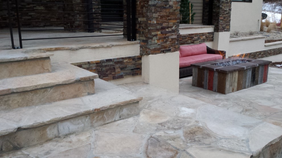 Patio fountain - large rustic backyard stone patio fountain idea in Denver with no cover