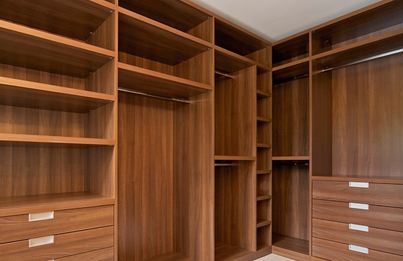Inspiration for a mid-sized walk-in wardrobe in Miami with medium wood cabinets.