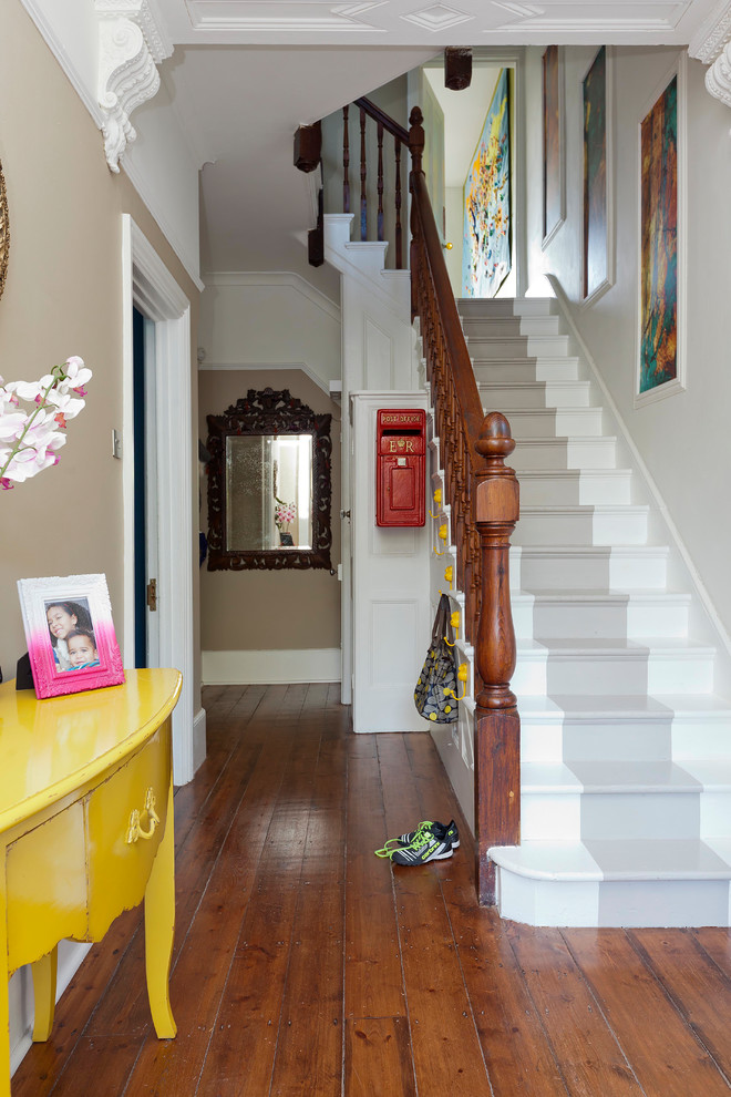 Inspiration for a mid-sized eclectic hallway in Kent with beige walls, laminate floors and brown floor.