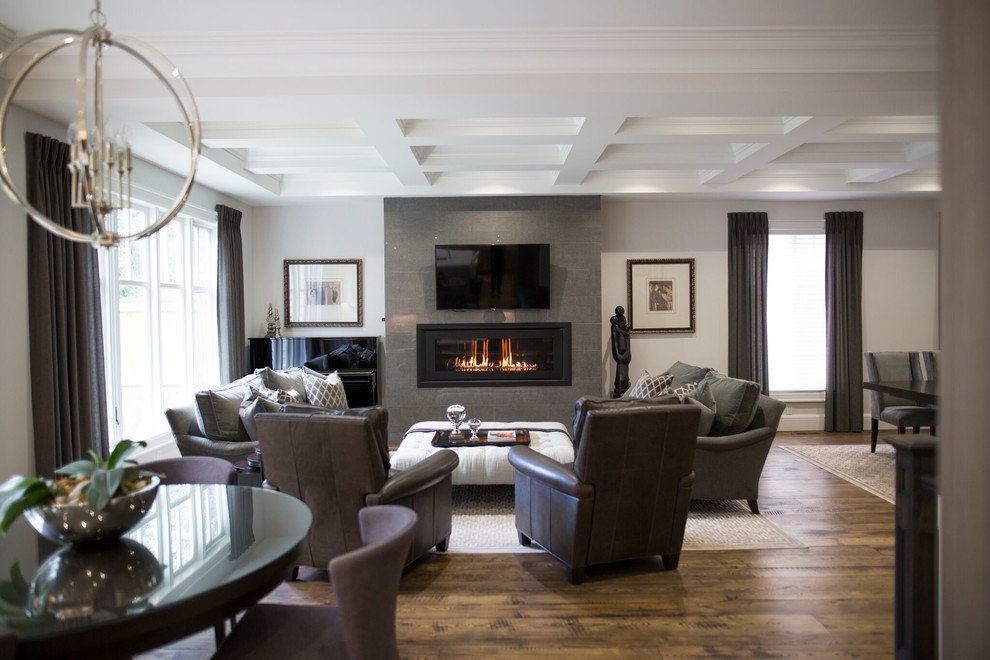 Photo of a mid-sized transitional enclosed living room in Toronto with white walls, a ribbon fireplace, a tile fireplace surround, a wall-mounted tv, brown floor and dark hardwood floors.