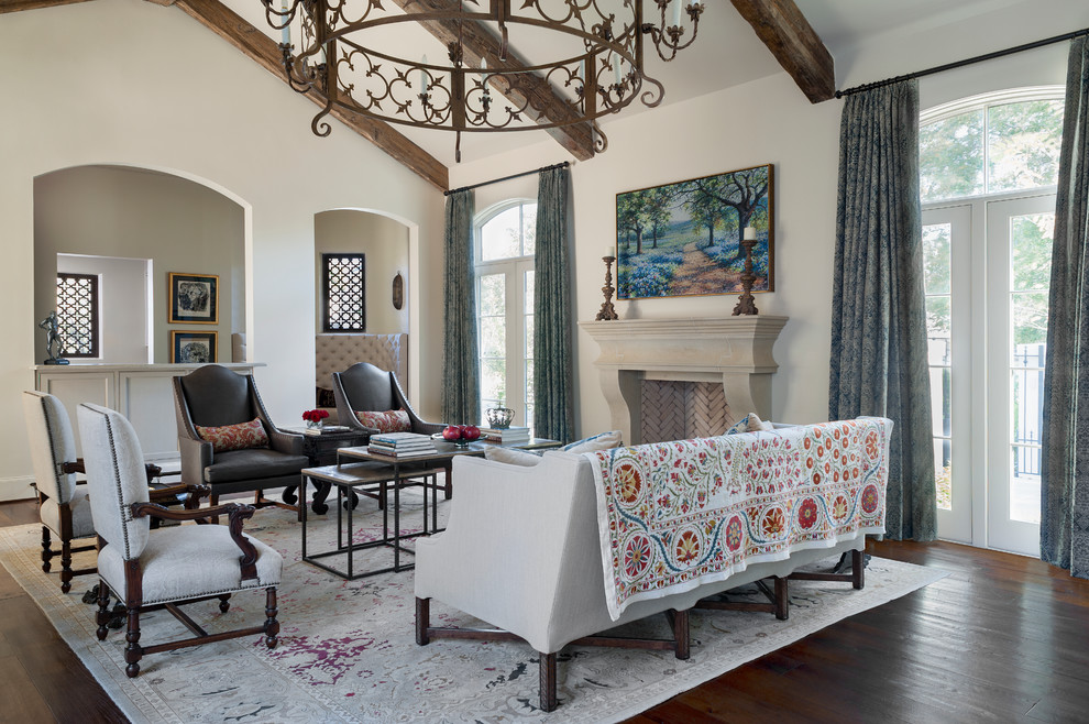 This is an example of a mediterranean living room in Houston with white walls and a standard fireplace.