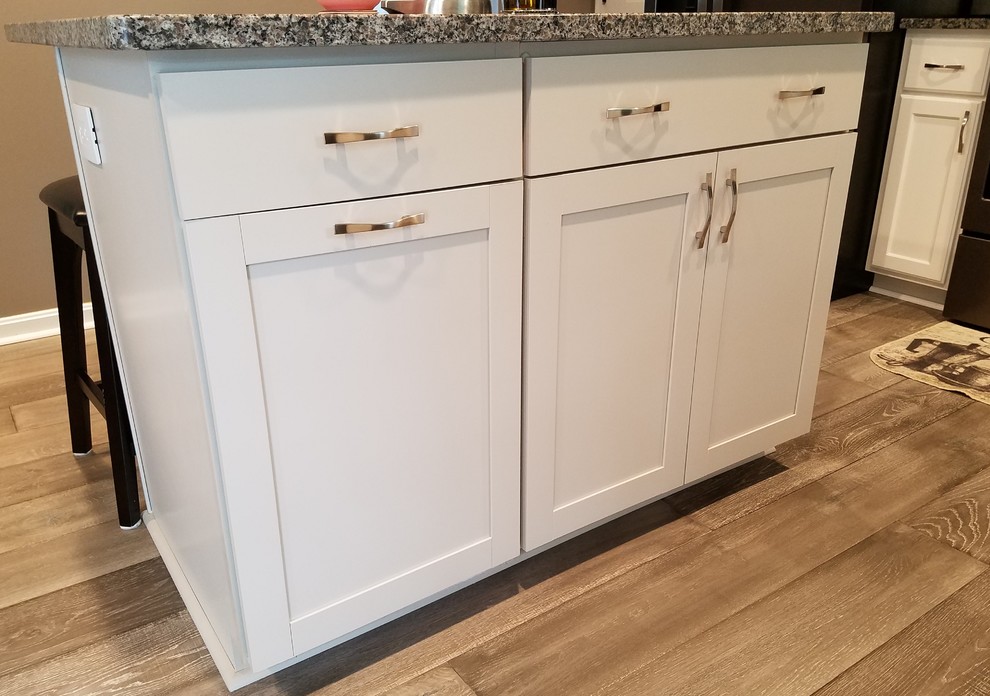 Eat-in kitchen - mid-sized transitional l-shaped medium tone wood floor and gray floor eat-in kitchen idea with an undermount sink, shaker cabinets, white cabinets, granite countertops, multicolored backsplash, ceramic backsplash, colored appliances, an island and multicolored countertops