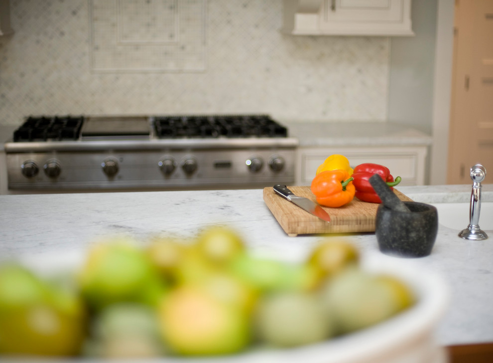 Inspiration for a transitional kitchen remodel with recessed-panel cabinets, white cabinets, marble countertops, white backsplash, mosaic tile backsplash, stainless steel appliances, an island and an undermount sink