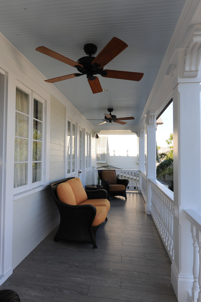 This is an example of a mid-sized traditional backyard verandah in New Orleans with decking and a roof extension.