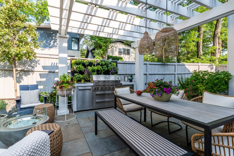 Inspiration for a small contemporary back patio in Minneapolis with natural stone paving and a pergola.