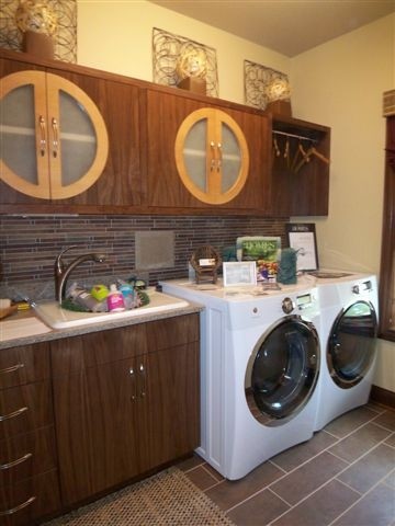 Inspiration for a small contemporary galley porcelain tile dedicated laundry room remodel in Other with a drop-in sink, glass-front cabinets, dark wood cabinets, granite countertops, beige walls and a side-by-side washer/dryer