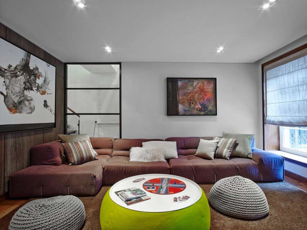 This is an example of a contemporary enclosed family room in New York with grey walls.
