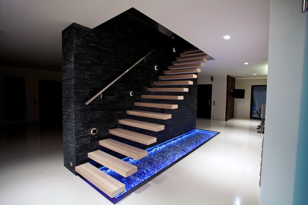 Inspiration for a modern wood floating staircase in Other with open risers, metal railing and decorative wall panelling.