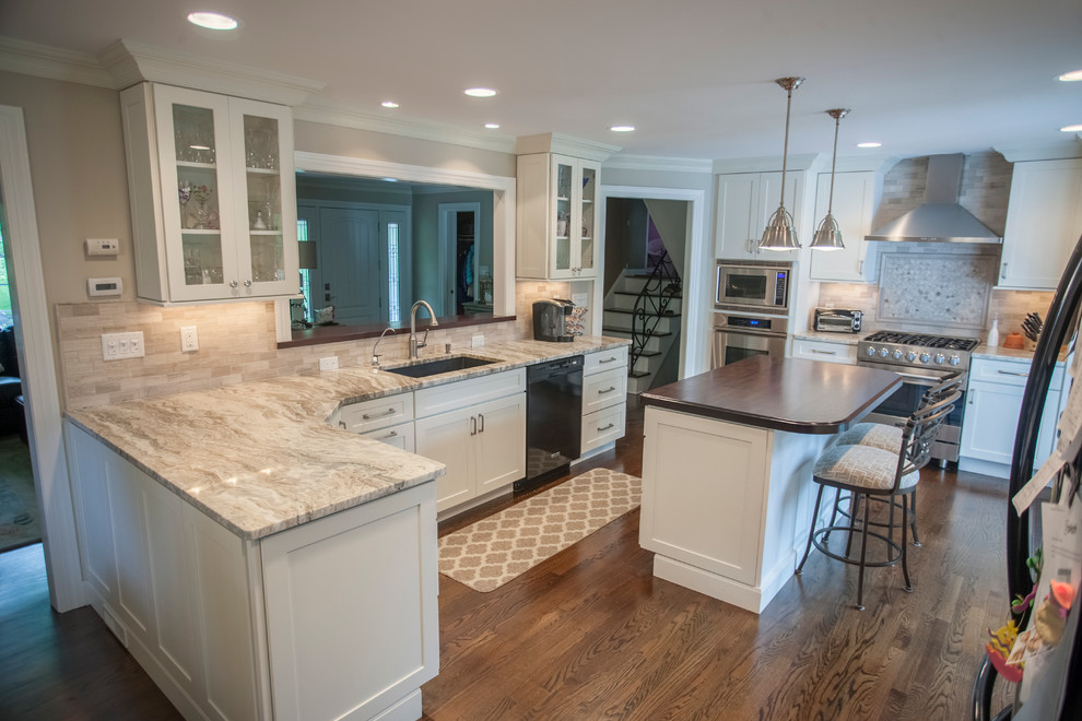 Mid-sized traditional galley open plan kitchen in New York with a drop-in sink, beaded inset cabinets, stainless steel appliances, dark hardwood floors and with island.