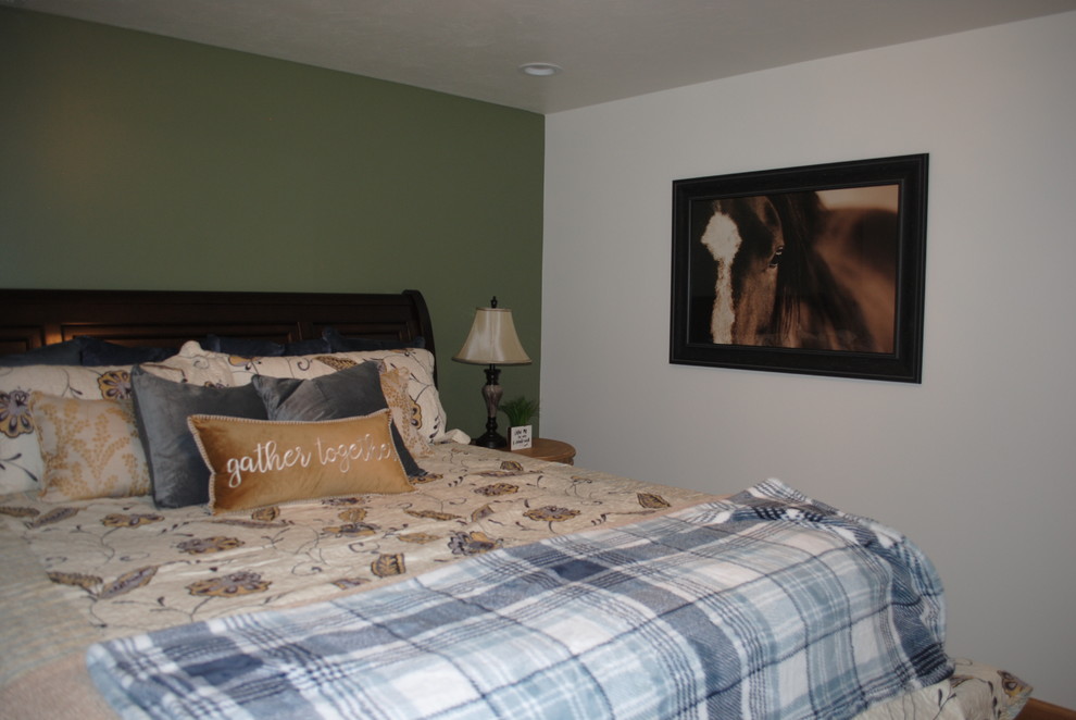 This is an example of a small country guest bedroom in Other with green walls, carpet, no fireplace and beige floor.
