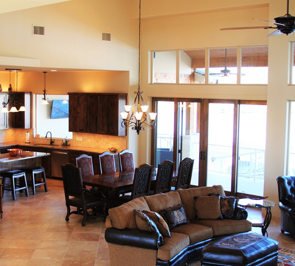 Example of a large l-shaped limestone floor open concept kitchen design in Austin with a drop-in sink, dark wood cabinets, granite countertops, beige backsplash, ceramic backsplash, stainless steel appliances and an island
