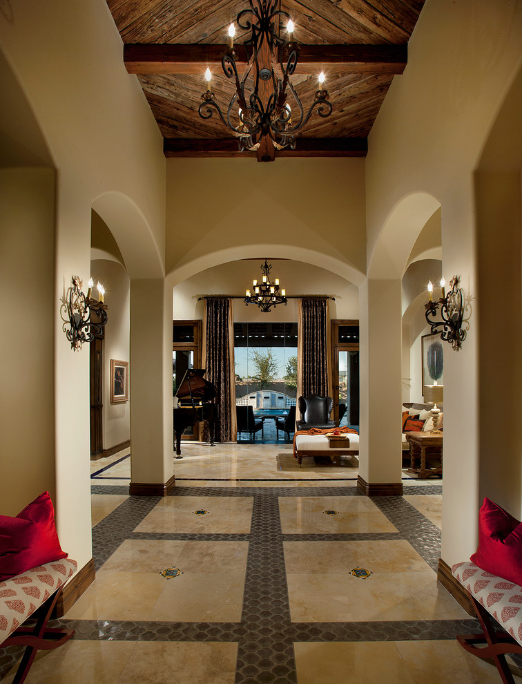 Inspiration for a large mediterranean travertine floor foyer remodel in Phoenix with beige walls and a dark wood front door