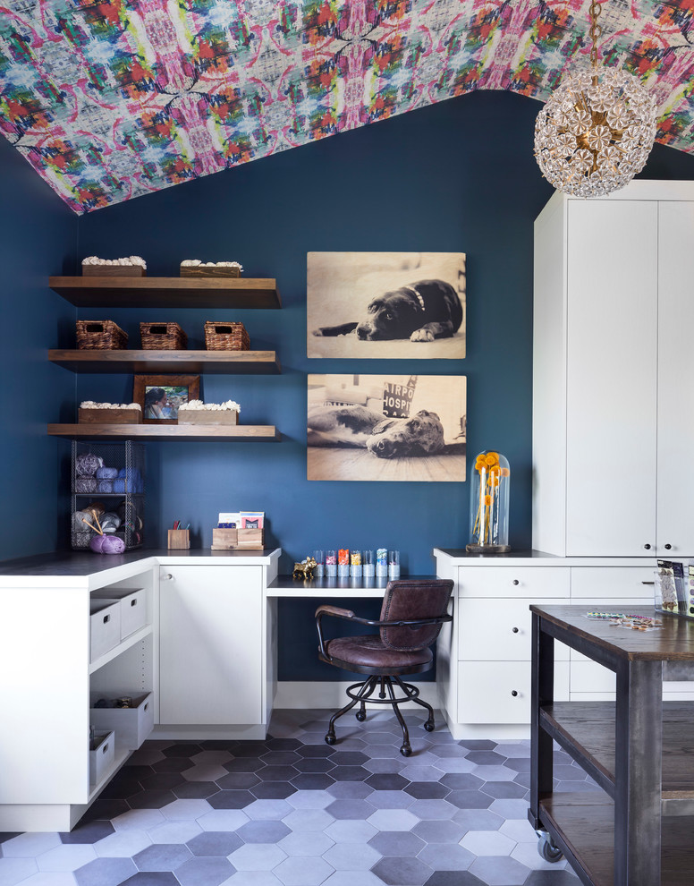 This is an example of a large eclectic craft room in Denver with blue walls, ceramic floors, no fireplace, a built-in desk and grey floor.