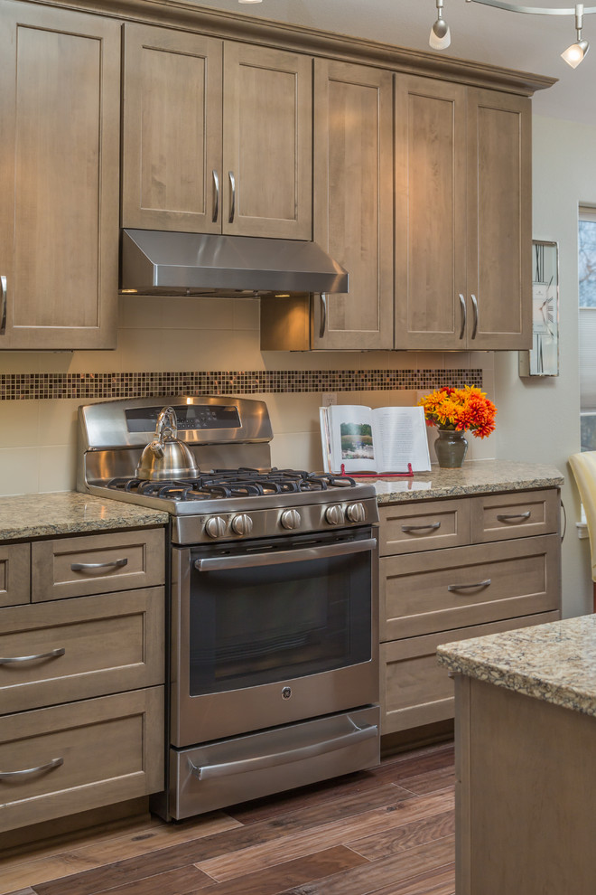 Example of a mid-sized transitional galley medium tone wood floor eat-in kitchen design with an undermount sink, recessed-panel cabinets, gray cabinets, quartz countertops, beige backsplash, ceramic backsplash, stainless steel appliances and no island
