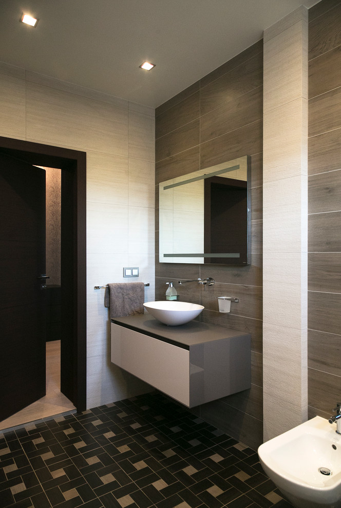 This is an example of a mid-sized contemporary bathroom in Moscow with flat-panel cabinets, beige cabinets, a drop-in tub, beige walls, porcelain floors, glass benchtops, a bidet and a vessel sink.