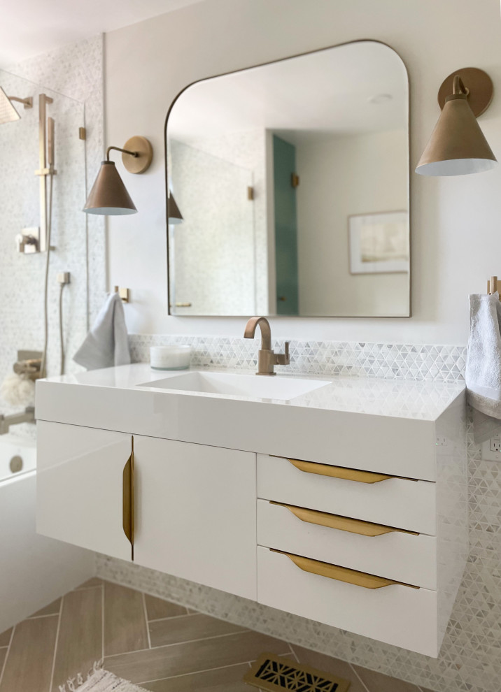 На фото: детская ванная комната среднего размера в стиле модернизм с плоскими фасадами, белыми фасадами, душем без бортиков, унитазом-моноблоком, разноцветной плиткой, керамогранитной плиткой, белыми стенами, полом из керамогранита, монолитной раковиной, столешницей из искусственного камня, бежевым полом, душем с распашными дверями, белой столешницей, нишей, тумбой под одну раковину и подвесной тумбой с