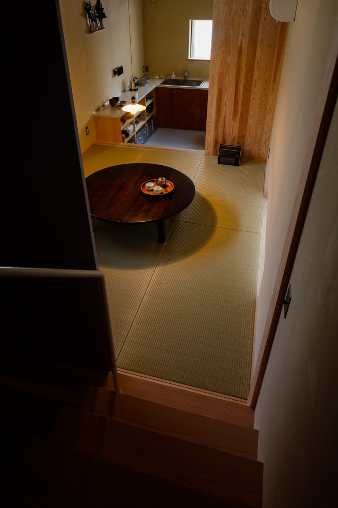 Aménagement d'une petite salle à manger ouverte sur le salon en bois avec un mur beige, un sol de tatami et poutres apparentes.