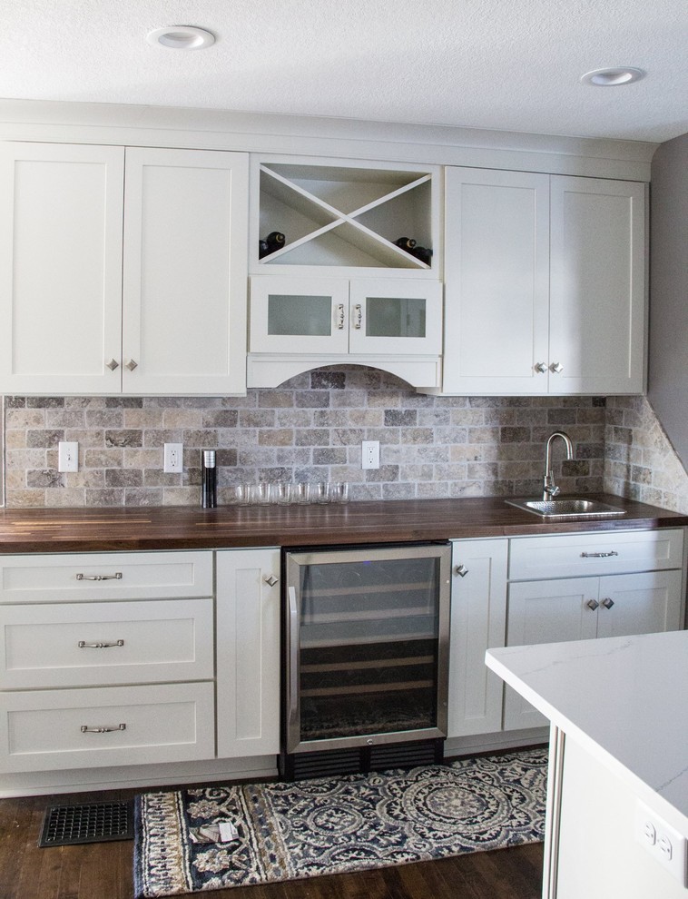 Large transitional single-wall eat-in kitchen in Minneapolis with a drop-in sink, recessed-panel cabinets, white cabinets, wood benchtops, multi-coloured splashback, stone tile splashback, stainless steel appliances, medium hardwood floors and with island.