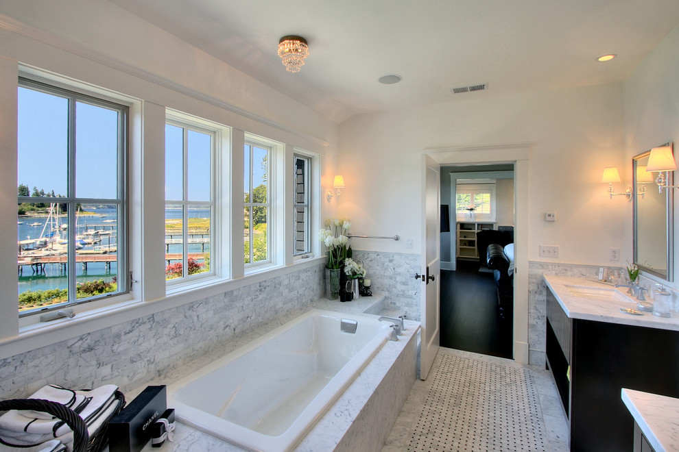 This is an example of a large traditional master bathroom in Seattle with an undermount sink, furniture-like cabinets, dark wood cabinets, marble benchtops, a drop-in tub, matchstick tile and mosaic tile floors.