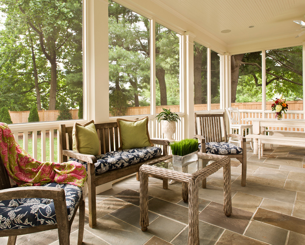 Mid-sized traditional backyard screened-in verandah in DC Metro with natural stone pavers and a roof extension.