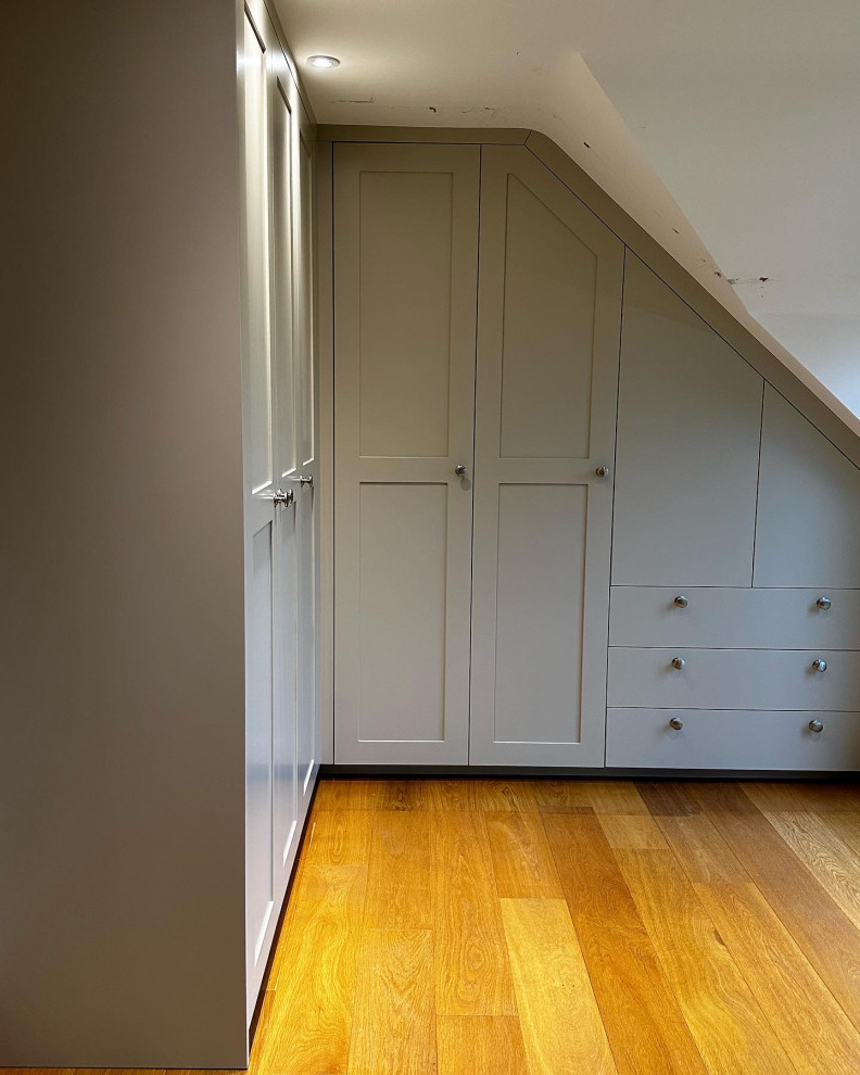 Cette image montre une grande armoire encastrée traditionnelle en bois clair neutre avec un placard à porte shaker.