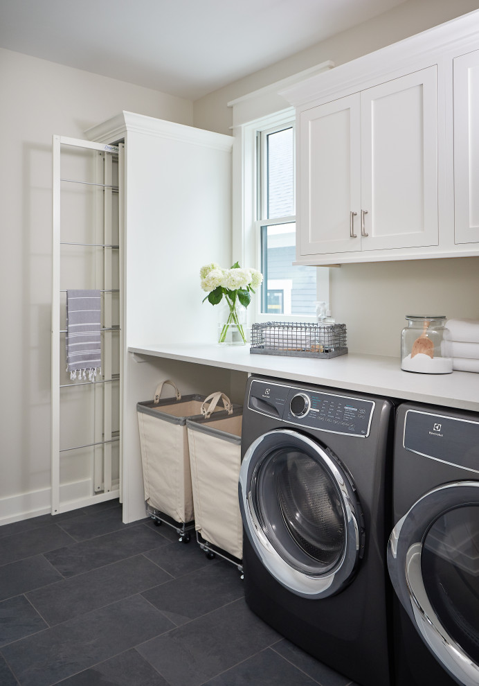 Mid-sized farmhouse galley slate floor and blue floor dedicated laundry room photo in Grand Rapids with recessed-panel cabinets, white cabinets, quartz countertops, white walls, a side-by-side washer/dryer and white countertops