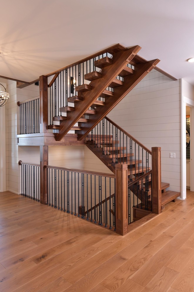 На фото: п-образная лестница в классическом стиле с деревянными ступенями, перилами из смешанных материалов и стенами из вагонки без подступенок с