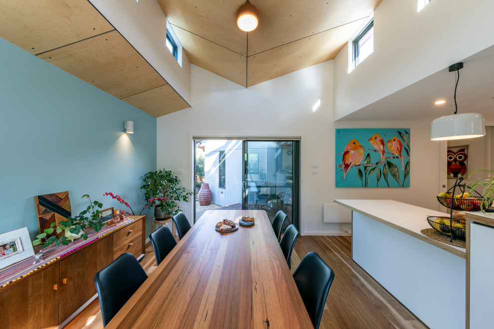 Ispirazione per una sala da pranzo aperta verso la cucina di medie dimensioni con parquet chiaro e soffitto in perlinato