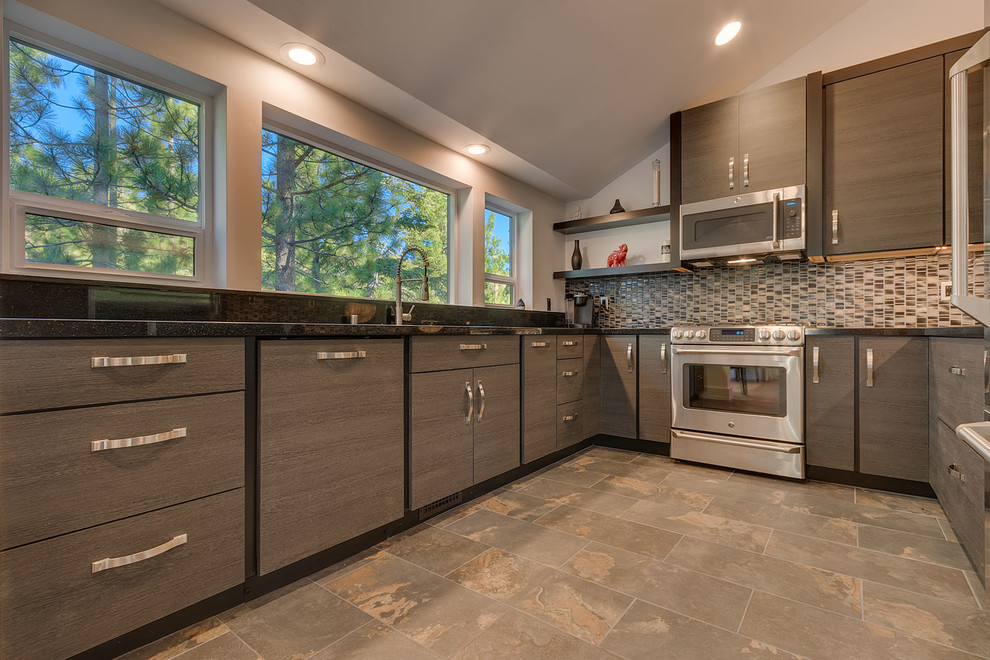 Inspiration for a mid-sized transitional u-shaped slate floor and brown floor enclosed kitchen remodel with an undermount sink, flat-panel cabinets, dark wood cabinets, granite countertops, multicolored backsplash, mosaic tile backsplash, stainless steel appliances and no island