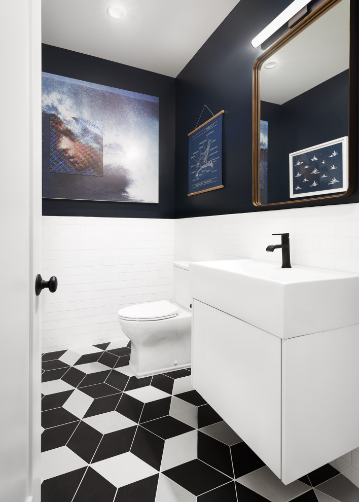 Idéer för industriella vitt toaletter, med släta luckor, vita skåp, en toalettstol med separat cisternkåpa, vit kakel, keramikplattor, blå väggar, klinkergolv i porslin, ett integrerad handfat och flerfärgat golv