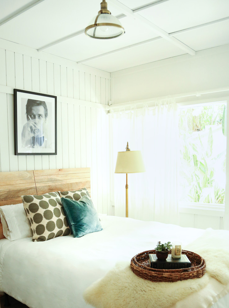 Photo of a small beach style guest bedroom in Los Angeles with white walls, laminate floors and grey floor.