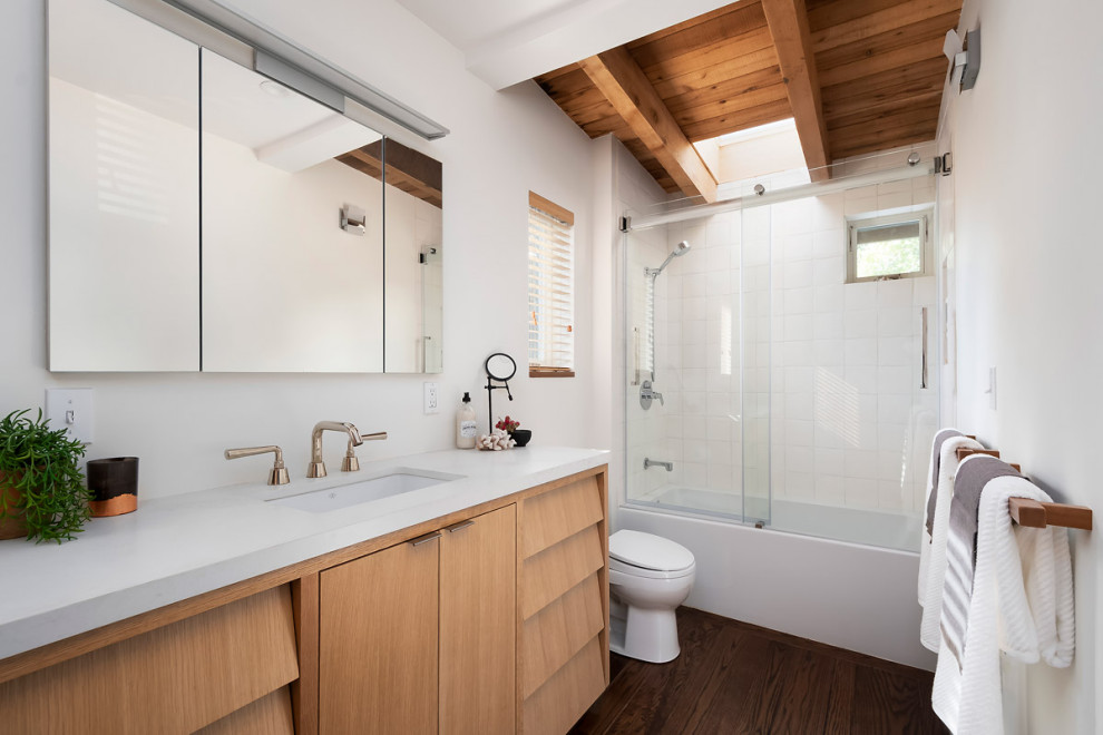Mid-sized contemporary master bathroom in Sacramento with white cabinets, white tile, white walls, medium hardwood floors, granite benchtops, brown floor, white benchtops, a single vanity and a built-in vanity.