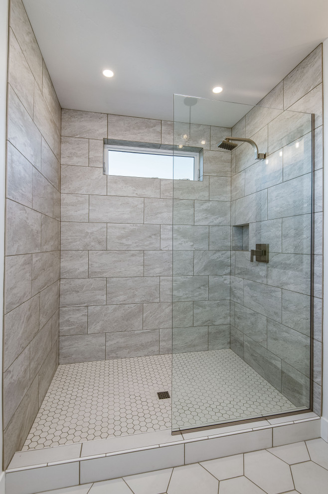 Idéer för ett stort grå badrum för barn, med skåp i shakerstil, vita skåp, ett fristående badkar, en öppen dusch, en toalettstol med separat cisternkåpa, grå kakel, stenhäll, vita väggar, betonggolv, ett undermonterad handfat, bänkskiva i akrylsten, brunt golv och med dusch som är öppen