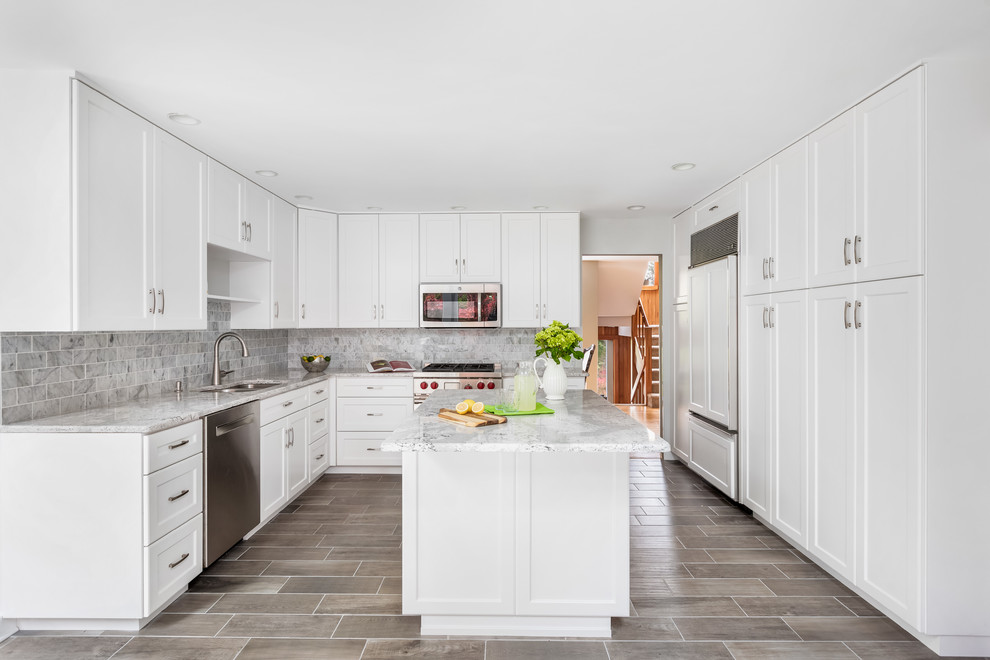 Large beach style l-shaped eat-in kitchen in Philadelphia with a single-bowl sink, shaker cabinets, white cabinets, quartzite benchtops, grey splashback, marble splashback, panelled appliances, ceramic floors, with island, grey floor and grey benchtop.