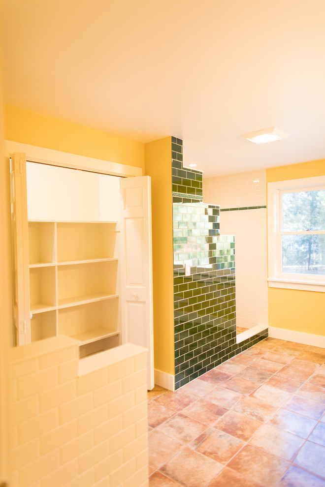 Photo of a large mediterranean master bathroom in Boston with white cabinets, a one-piece toilet, white tile, subway tile, yellow walls, terra-cotta floors, a drop-in sink, tile benchtops, red floor and an open shower.